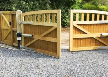 کاربرد جک درب پارکینگ بسیار گسترده است. جک پارکینگی بازویی نصب شده بر روی یک درب قهوه ای روشن که در حال باز شدن است.