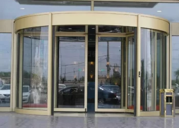 درب اتوماتیک در انواع مختلف راهبند، جک پارکینگی و درب های شیشه ای اتوماتیک تولید می شود. درب اتوماتیک شیشه ای زرد رنگ که در ورودی یک ساختمان نصب شده است.