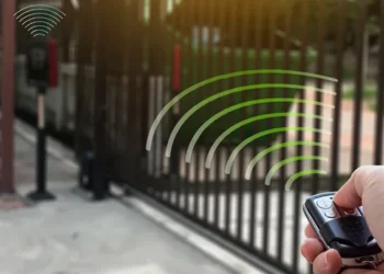 فردی در حال باز کردن درب پارکینگ متصل به جک پارکینگی به واسطه ریموت.