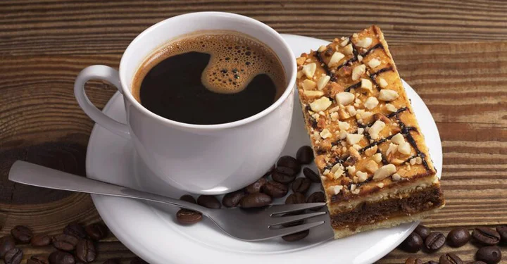 یک فنجان قهوه که در کنار یک تکه کیک قرار گرفته است. | برقیجات