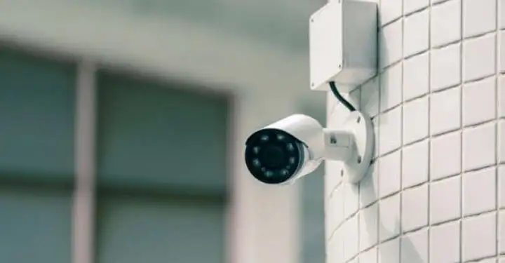 دوربین بولت که در یک دیوار سفید رنگ نصب شده است و در حال نظارت محیط است.