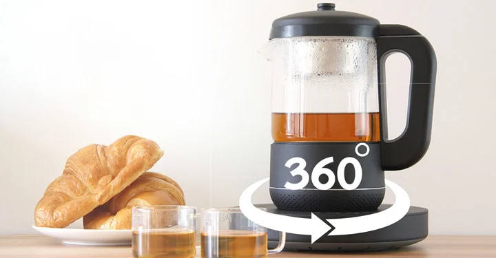 یک چای‌ساز که بر روی یک میز در کنار فنجان چای و دو عدد کروسان قرار گرفته است و از قابلیت چرخش 360 درجه پشتیبانی می‌کند. | مجله برقیجات