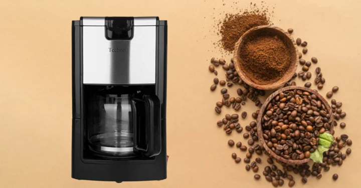 قهوه ساز تکنو te-816 در بک گراند کرم در کنار دانه های قهوه قرار دارد.