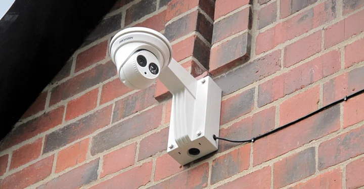 دوربین تورت سفید رنگ که بر روی یک دیوار نصب شده است. 