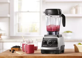 یک عدد غذاساز چندکاره که دارد میوه ها را خرد و مخلوط می‌کند.